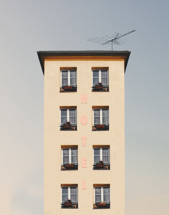services-04 A minimalist hotel facade showcasing clean lines, symmetry, and bright daylight.